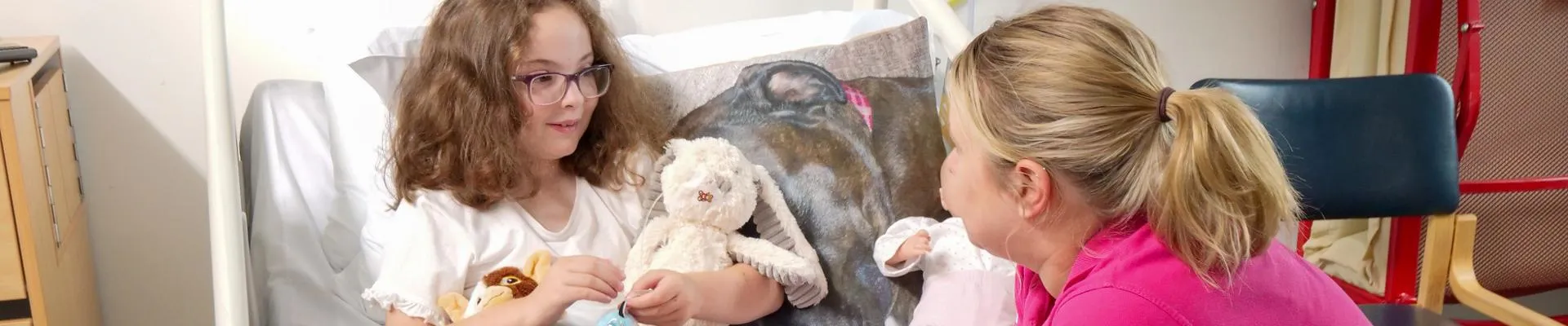 A play specialist talking to a child in a hospital bed